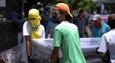 Hombres cargan el ataúd de un fallecido por coronavirus en el cementerio en Guayaquil el 12 de abril de 2020.