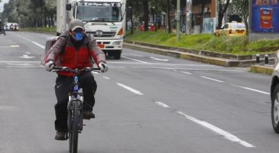 Un hombre con mascarilla circula a bordo de una bicicleta, en el norte de Quito; este lunes 4 de mayo de 2020, en el primer día del distanciamiento social.