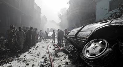 Los equipos de rescate se reúnen en el lugar del accidente de un avión de pasajeros en una zona residencial cerca de un aeropuerto en Karachi.