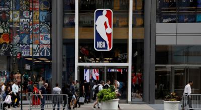 Ciudadanos caminan por los exteriores de una tienda de la NBA en Nueva York, Estados Unidos, el 14 de junio de 2020.