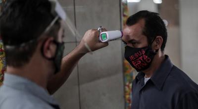 Un guardia mide la temperatura a un hombre que entra a un mercado en Brasil, el 24 de junio. 
