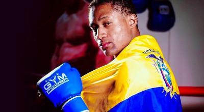 Fotografía del boxeador ecuatoriano, Alexander Espinoza boxeador ecuatoriano, con la bandera Tricolor.