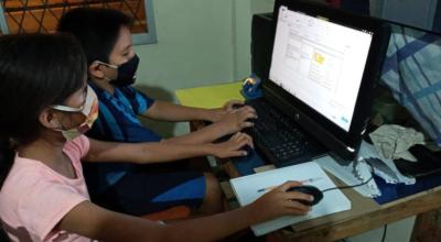 Dos niños comparten una computadora en un centro de cómputo en la parroquia Pacayacu, de la provincia de Sucumbíos, en 2020.