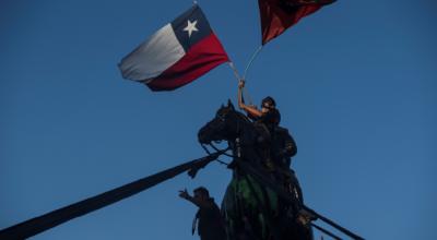 Manifestantes ondean banderas de Chile hoy, durante una toma de la Plaza Italia, en las horas previas al resultado del plebiscito constitucional, en Santiago (Chile), el 25 de octubre de 2020.