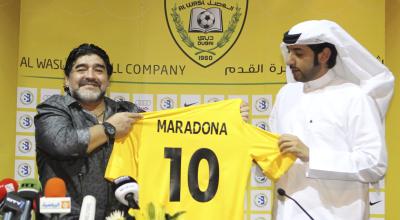 Diego Armando Maradona posando con su camiseta del Al-Wasl, junto al presidente del club, Marwan Bin Bayat durante una rueda de prensa donde se presentó como nuevo entrenador en el hotel Jumeirah Zabeel Saray, el 11 de septiembre de 2011, en Dubai.