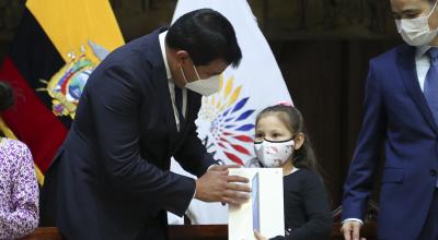 El presidente de la Asamblea, César Litardo, entrega una tablet a una niña el 11 de septiembre de 2020.