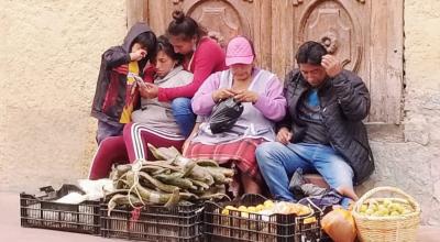 Un grupo de personas y un niño venden frutas en el centro de Cuenca, el 14 de enero de 2020. 
