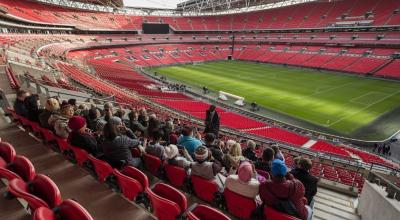 Aficionados en escuchando al guía del tour del estadio de Wembley.