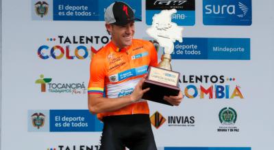 El ciclista José 'Tito' Hernández, del Team Medellín, levanta el trofeo de campeón de la Vuelta a Colombia 2021, en Bogotá, el domingo 25 de abril.