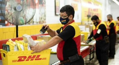 Trabajadores de un courier carga un paquete en Ecuador, en 2021. 