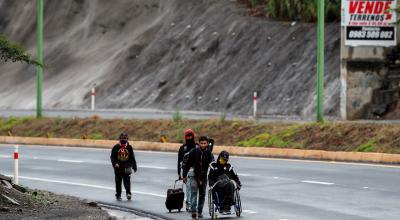 Ciudadanos venezolanos, uno de ellos con discapacidad, transitaban el 28 de mayo de 2020 en una carretera cercana a Quito (Ecuador).
