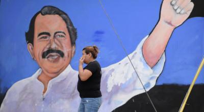 Una mujer camina frente a un mural del presidente Daniel Ortega, en Managua (Nicaragua), el 21 de junio de 2021.