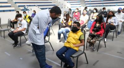 En médico conversa con un adolescente antes de aplicarle la vacuna contra el Covid-19, el 28 de julio de 2021, en Quito.