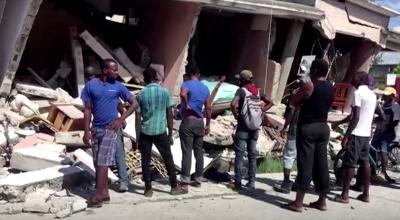 Personas en los alrededores de una construcción colapsada en Los Cayos, Haití, después de un terremoto este 14 de agosto de 2021.