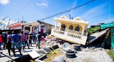 Varias personas permanecen junto a los escombros de una casa en Haití, el 15 de agosto de 2021.