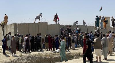 Afganos intentan cruzar el muro del aeropuerto internacional Hamid Karzai, en Kabul, para salir del país, el 16 de agosto de 2021.