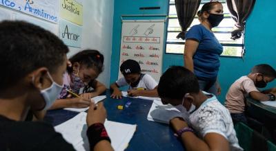 Niños hacen tareas en sus cuadernos durante una clase en la casa, el 20 de agosto de 2021, en Petare, Caracas (Venezuela).