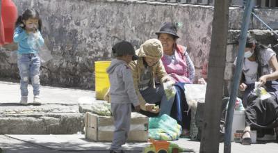 Dos niños acompañan a sus padres en la venta de productos en Quito, el 28 de octubre de 2021.