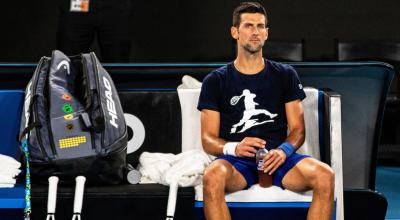 El tenista serbio Novak Djokovic descansa durante un entrenamiento para participar en el Abierto de Australia en el Melbourne Park, el viernes 14 de enero de 2022.