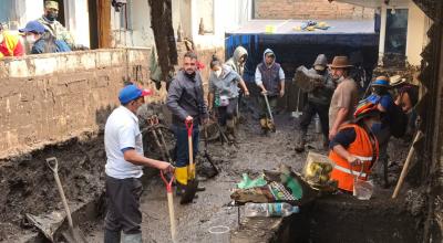 Varios voluntarios en las tareas de limpieza de calles de La Comuna, tras el aluvión, en Quito. Imagen del 2 de febrero de 2022.