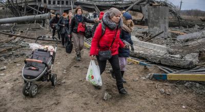 Civiles cruzan debajo de un puente bombardeado por las fuerzas rusas en Irpín, Kiev, el 6 de marzo de  2022.