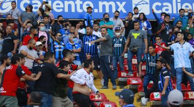 Cientos de hinchas del Querétaro y del Atlas protagonizaron una batalla en el estadio La Corregidora, en México, el sábado 5 de marzo de 2022. 