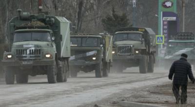 Vehículos militares del Ejército ruso circulan por una calle, después de que el presidente Vladimir Putin autorizara una operación militar en la ciudad de Armyansk, Crimea, el 24 de febrero de 2022. Hoy se cumple un mes de guerra.