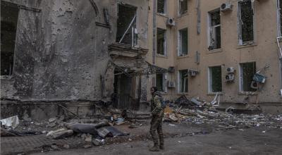 Un miembro del ejército ucraniano se encuentra junto al edificio dañado de la Administración Estatal Regional de Kharkiv, que fue fuertemente bombardeado por las fuerzas rusas, en Kharkiv, noreste de Ucrania, el 27 de marzo de 2022.