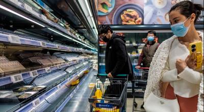 Varias personas compran comida en un supermercado casi vacío antes del confinamiento selectivo en Shanghái, el 25 de marzo de 2022.
