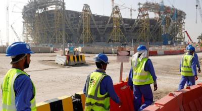 Trabajadores llevan materiales a uno de los estadios de Qatar, en febrero de 2021.