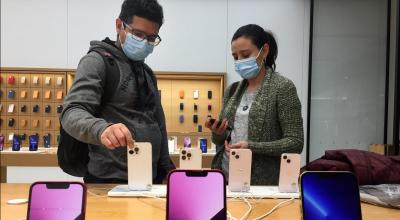 Dos personas mirando nuevos teléfonos de Apple en una tienda de Canadá, el 30 de marzo de 2022.