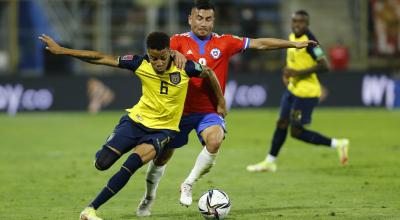 El jugador Byron Castillo de Ecuador pelea una pelota con Jean Meneses de Chile, el 16 de noviembre de 2021, en un partido de las Eliminatorias al Mundial de Catar 2022. 