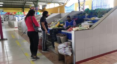 Dos personas hacen compras en el mercado de Conocoto, en el suroriente de Quito, el 29 de junio de 2022.