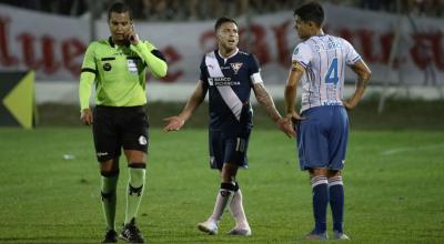 El árbitro Marlon Vera escucha a sus compañeros en el VAR durante el partido entre Liga y 9 de Octubre, en Milagro, el 1 de octubre de 2022.