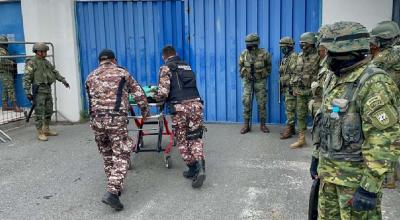 Agentes penitenciarios ingresan una camilla a la Cárcel de Latacunga para extraer a los heridos tras el motín del 4 de octubre de 2022.