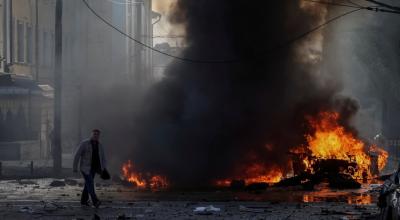 Un conductor camina cerca de su coche quemado tras el ataque militar ruso, mientras continúa la invasión rusa en el centro de Kiev, Ucrania. 10 de octubre de 2022. 