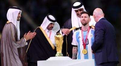 El príncipe Jassim bin Hamad bin Khalifa Al Thani aplaude mientras el emir de Qatar, el jeque Tamim bin Hamad Al Thani, le pone un Bisht a Lionel Messi de Argentina junto al presidente de la FIFA, Gianni Infantino durante la ceremonia de entrega de premios de la final del Mundial.