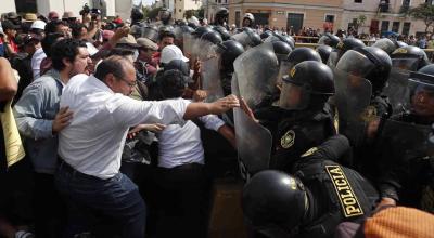 Policías chocan hoy con ciudadanos junto a la sede de la Prefectura, donde se encuentran los manifestantes detenidos. Lima, 21 de enero de 2023