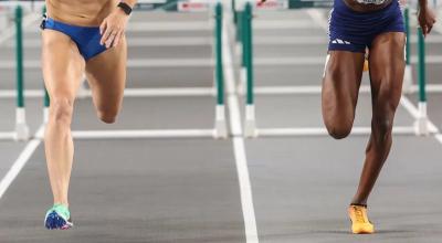 Imagen de las piernas de dos atletas durante una competencia internacional en 2022.