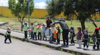 Niños menores de cinco años cruzan una calle de Cuenca en la parroquia Monay. 