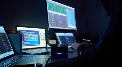 Imagen referencial. Un cibercriminal detrás de varios computadores, el 27 de febrero de 2023. 