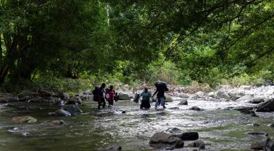 Varias personas cruzando uno de los tramos de la selva del Darién, entre Colombia y Panamá, septiembre de 2022. 