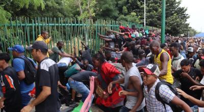 Grupos de migrantes rompen el cerco de seguridad para exigir papeles migratorios hoy, Tapachula, estado de Chiapas (México).