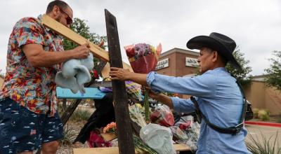 Ciudadanos comienzan a construir cruces para una vigilia en recuerdo de los que murieron en un tiroteo masivo en la entrada del Allen Premium Outlet Mall en Allen, Texas.