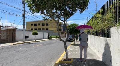 Una persona camina con una sombrilla en una calle del norte de Quito, el 8 de mayo de 2023. El Inamhi alerta sobre el peligro de no protegerse.