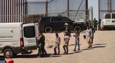 Migrantes detenidos son llevados por miembros de la Patrulla Fronteriza estadounidense a un vehículo en la frontera México-Estados Unidos, el 11 de mayo de 2023. 