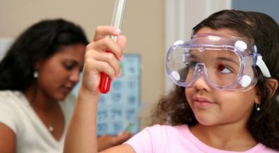 Imagen referencial. Una niña sosteniendo un tubo de ensayo en un laboratorio. 