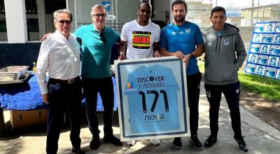 Yuber Mosquera (medio) sostiene una camiseta de Universidad Católica en el complejo de La Armenia, el 19 de junio de 2023.