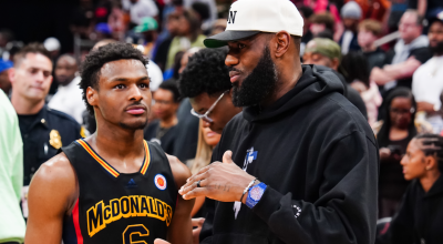 Bronny James habla con su padre, LeBron James, durante un partido de Básquet en Houston, el 28 de marzo de 2023.