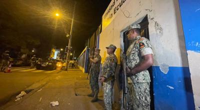 Tres militares custodian una escuela en Guayaquil, que servirá como recinto electoral en las presidenciales, 16 de agosto de 2023. 